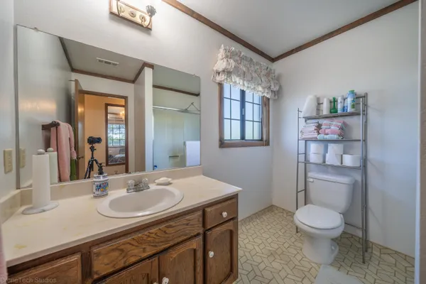 a bathroom with a granite countertop sink toilet a mirror and shower