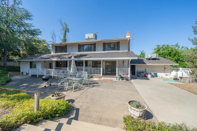a front view of a house with yard and parking