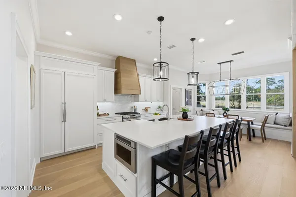 a kitchen with a table chairs stove and wooden floor