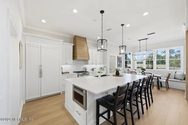 a kitchen with a table chairs stove and wooden floor