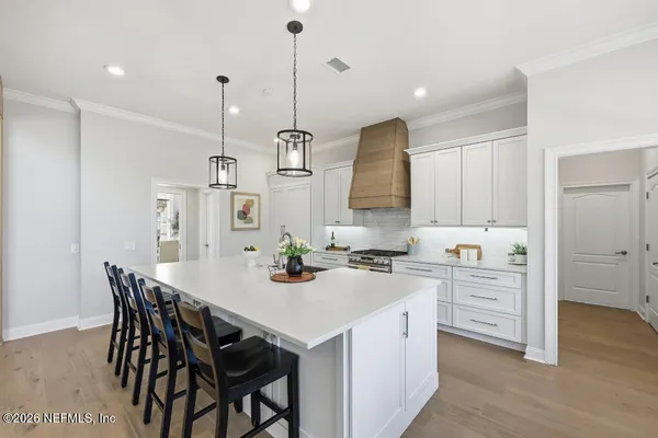 a kitchen with a stove a sink a dining table and chairs
