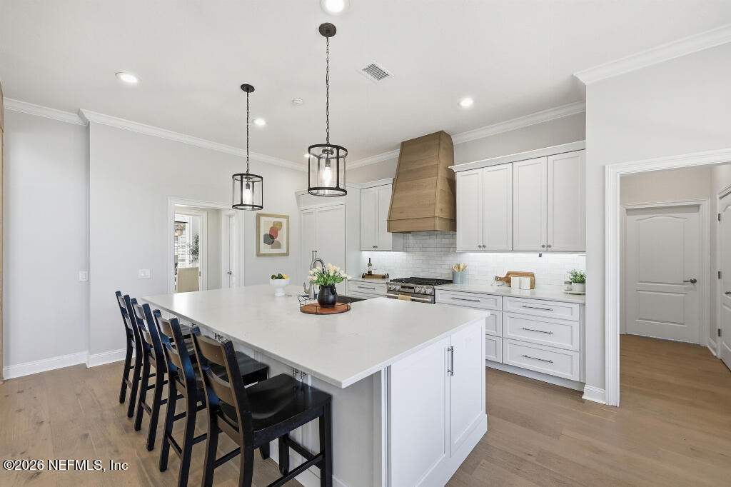 7956 Hollyridge Road Jacksonville, FL 32256 - Photo 15 of 50 a kitchen with a stove a sink a dining table and chairs