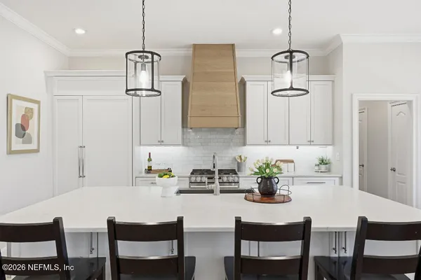 a white kitchen with a table and chairs in it