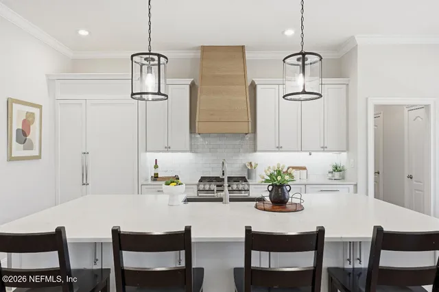 a white kitchen with a table and chairs in it