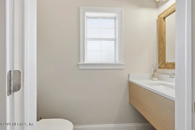 a bathroom with a sink a toilet and a window