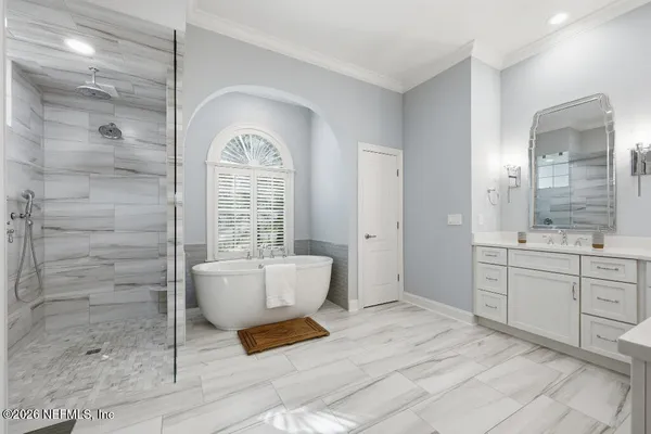 a spacious bathroom with a double vanity sink a mirror and a bathtub