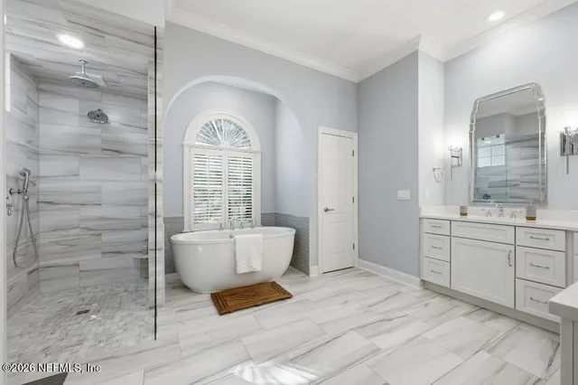 a spacious bathroom with a double vanity sink a mirror and a bathtub