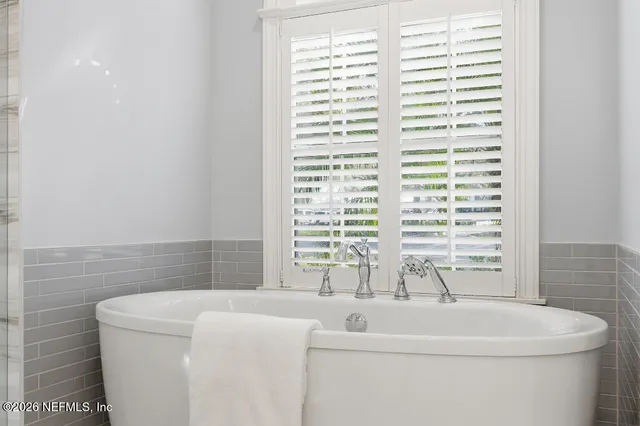 a bathroom with a bathtub and a window