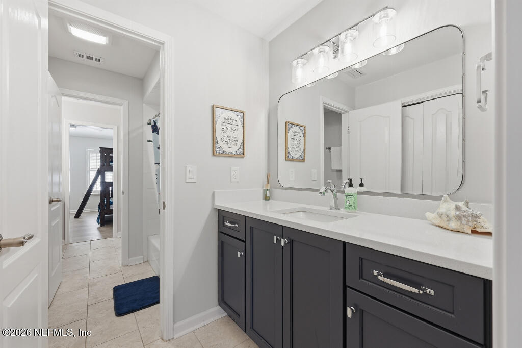 7956 Hollyridge Road Jacksonville, FL 32256 - Photo 38 of 50 a bathroom with a sink a vanity and a mirror