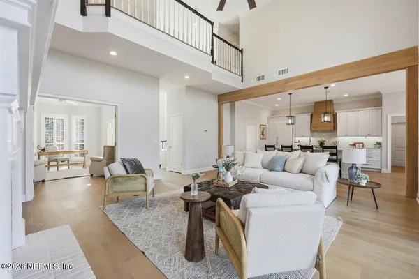 a living room with furniture kitchen view and a wooden floor