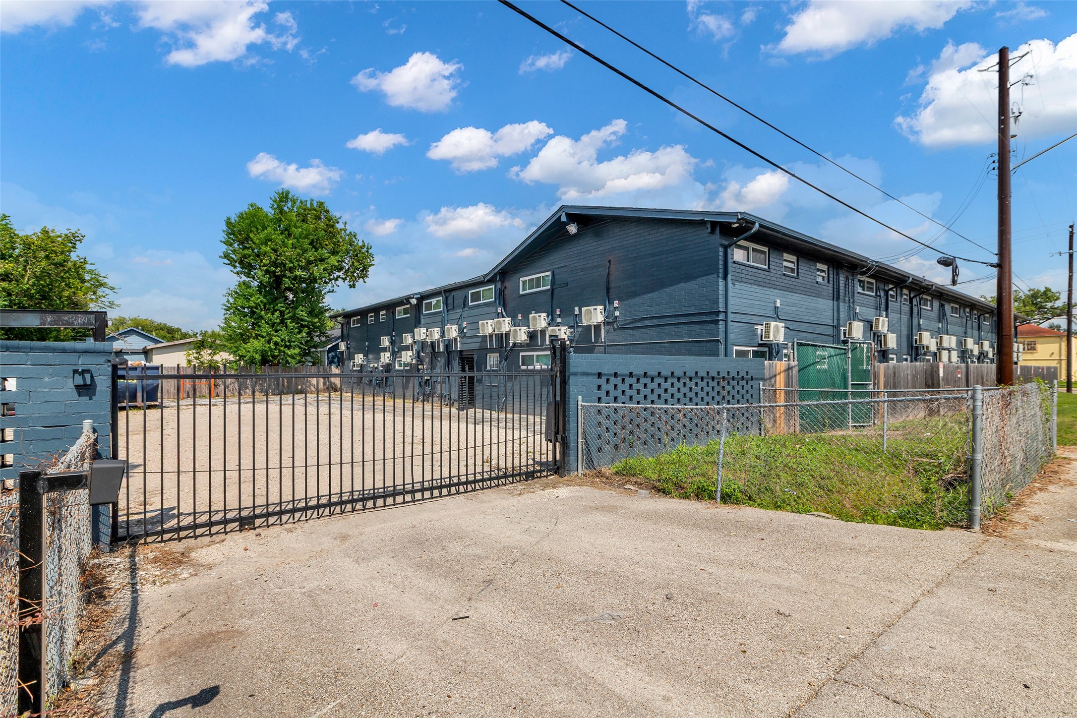4706 Yellowstone Boulevard, Unit 21 Houston, TX 77021 - Photo 24 of 24 This photo shows a gated apartment complex with a paved entrance and surrounding fence.