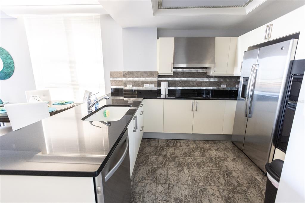 1350 Main Street, Unit 709 Sarasota, FL 34236 - Photo 15 of 56 a kitchen with stainless steel appliances granite countertop a sink a stove and a refrigerator
