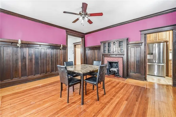 a dining room with wooden floor a chandelier a wooden table and chairs