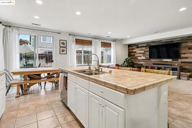 a kitchen with a table chairs sink and refrigerator