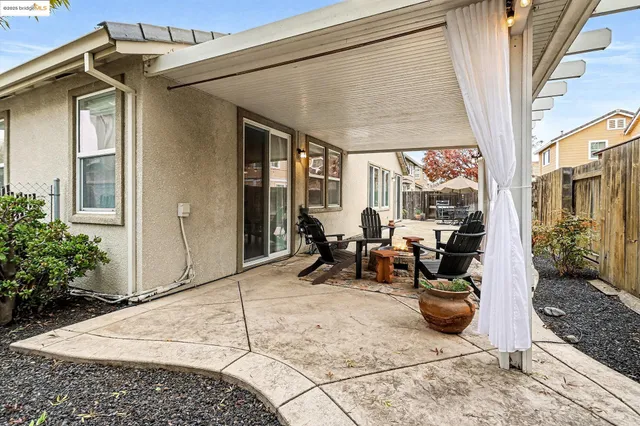 a patio with a table and chairs and potted plants