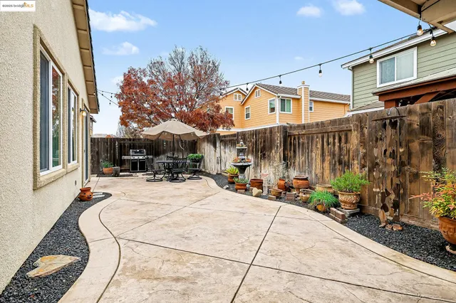 a view of a patio with table and chairs potted plants and a barbeque
