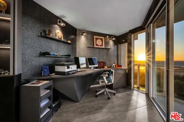 a view of a workspace with furniture and a window