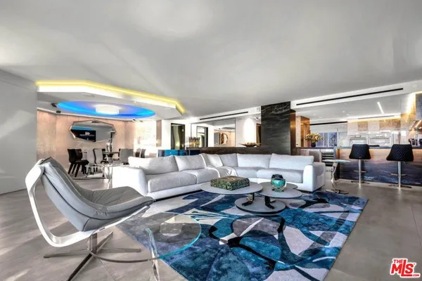 a living room with lots of furniture and view of kitchen