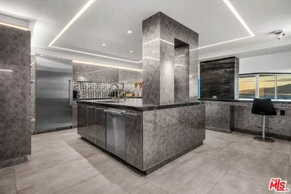 a kitchen with stainless steel appliances granite countertop a sink and a refrigerator