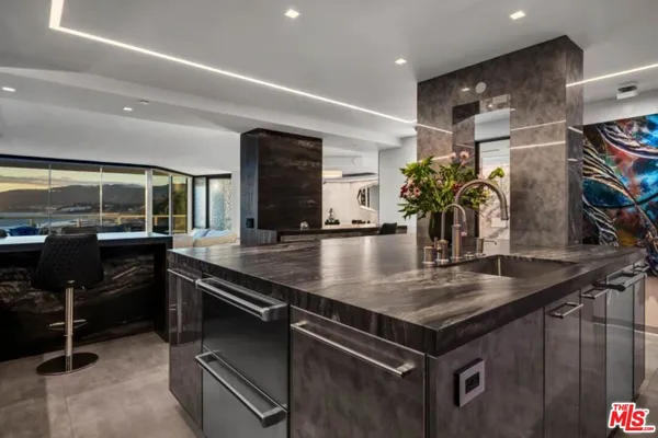 a kitchen with stainless steel appliances granite countertop a sink and a refrigerator