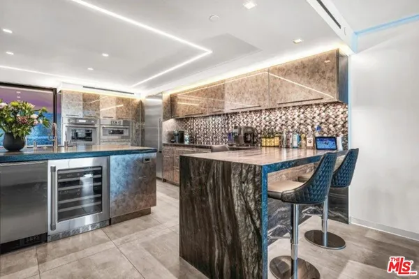 a kitchen with a sink and chairs