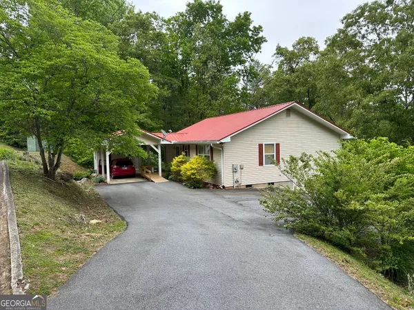 a view of a house with a yard and large tree