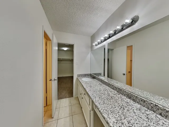 a bathroom with a granite countertop sink and a mirror