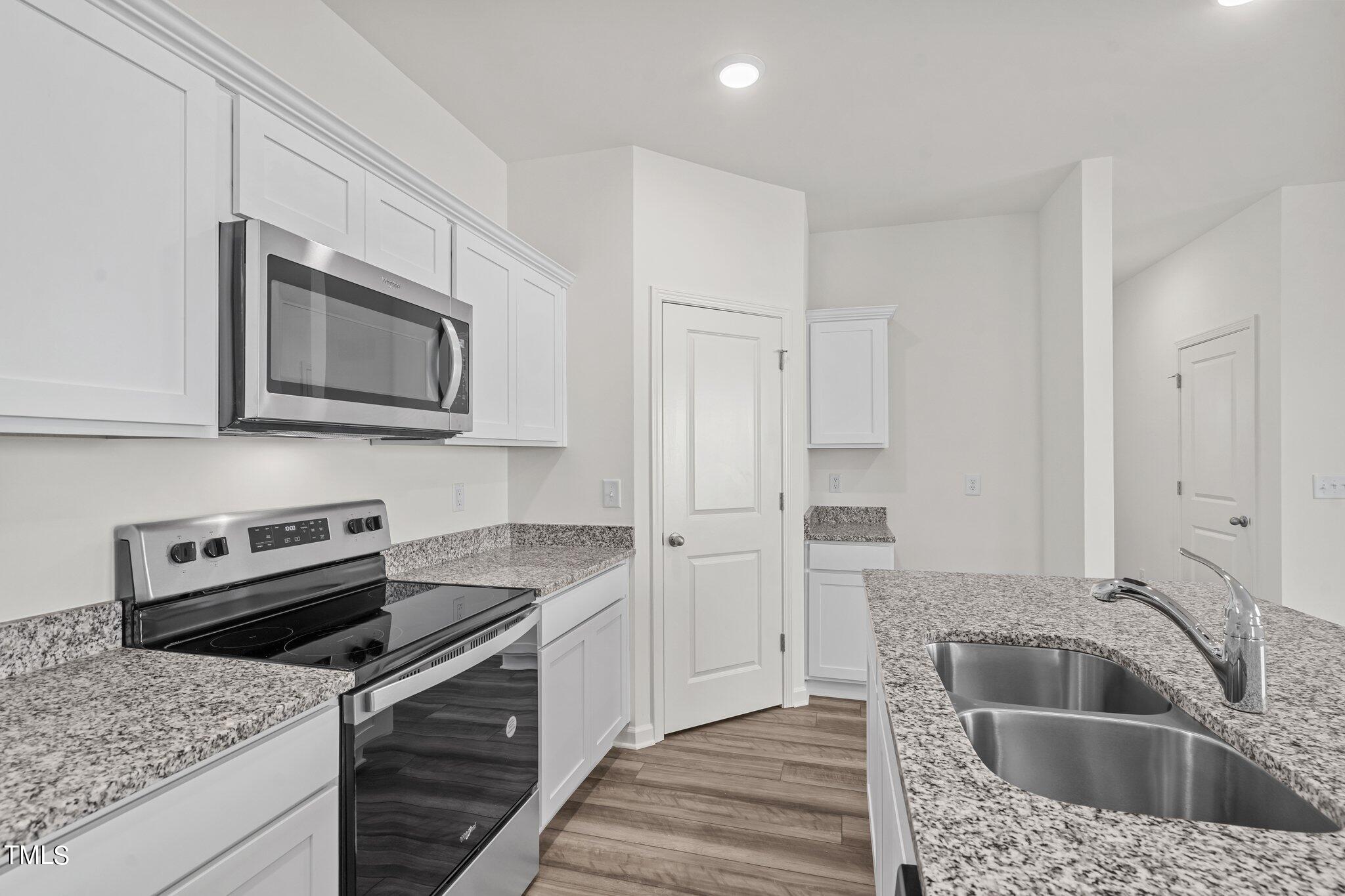730 Piaggio Lane Spring Hope, NC 27882 - Photo 5 of 25 a kitchen with stainless steel appliances granite countertop a sink dishwasher microwave stove and refrigerator