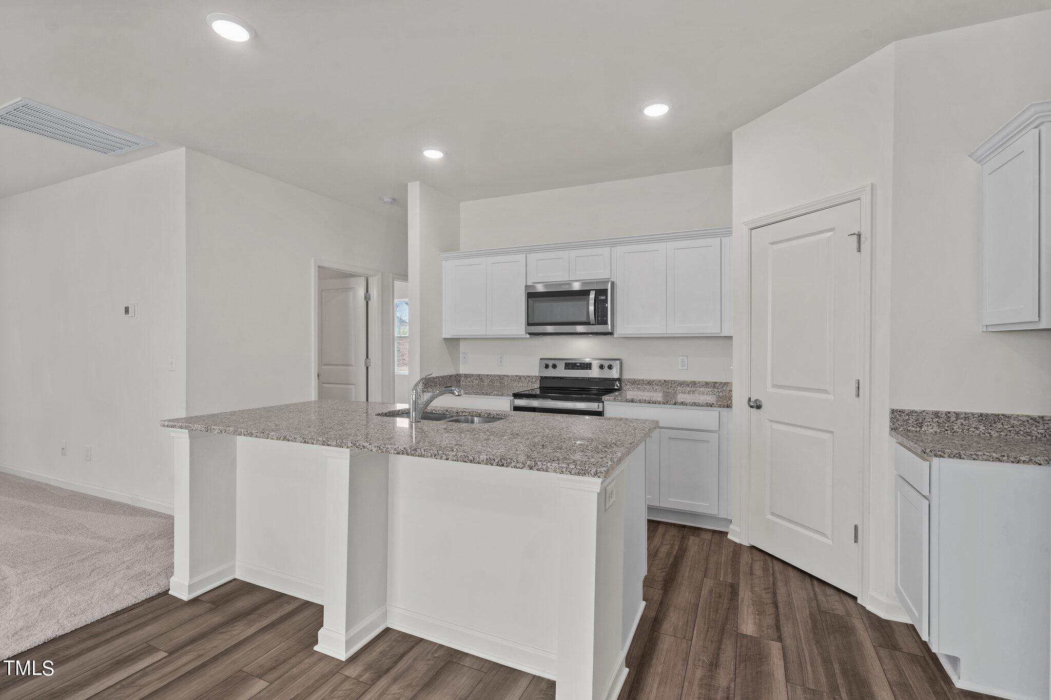 730 Piaggio Lane Spring Hope, NC 27882 - Photo 10 of 25 a kitchen with a sink a stove a refrigerator and white cabinets