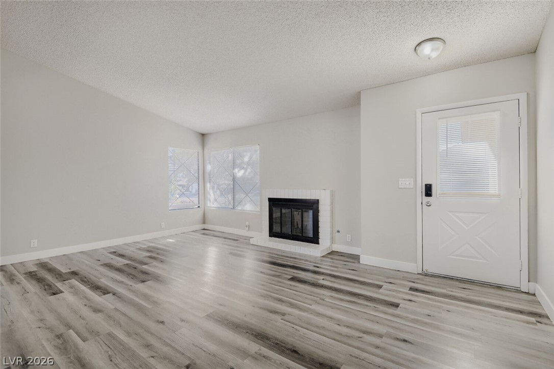 2343 Valleywood Road Henderson, NV 89014 - Photo 8 of 29 Luminous living area features attractive flooring and a charming corner fireplace.