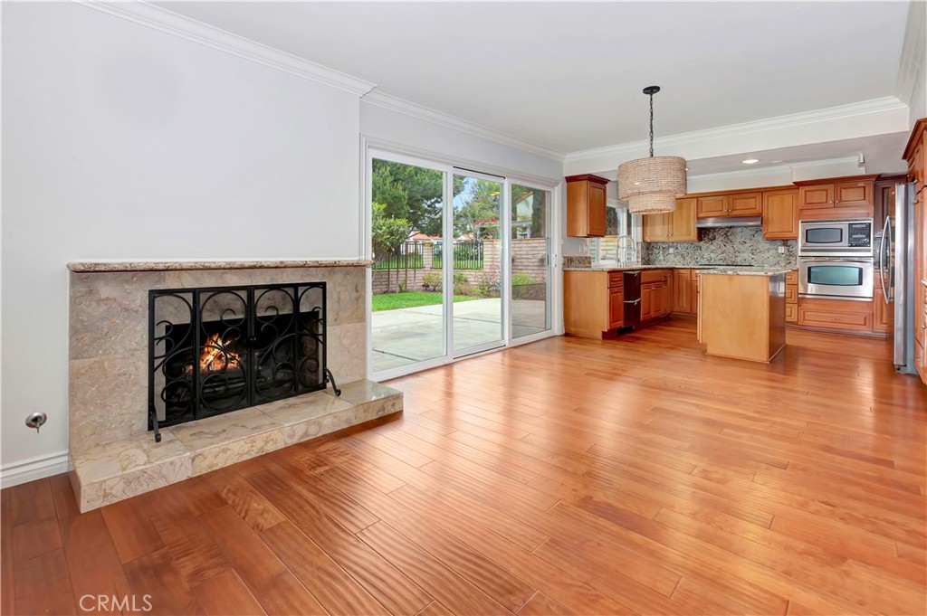 4625 Green Tree Lane Irvine, CA 92612 - Photo 7 of 29 a open kitchen with a fireplace and wooden floor