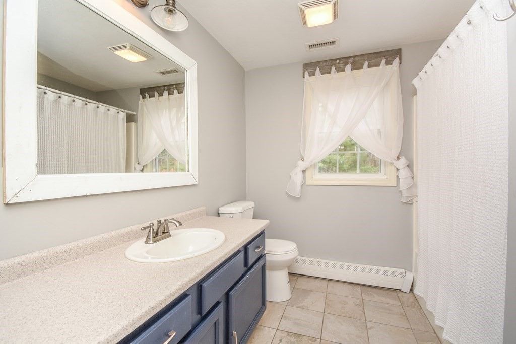 26 Rush Pond Road Lakeville, MA 02347 - Photo 21 of 38 a bathroom with a sink toilet a mirror and vanity