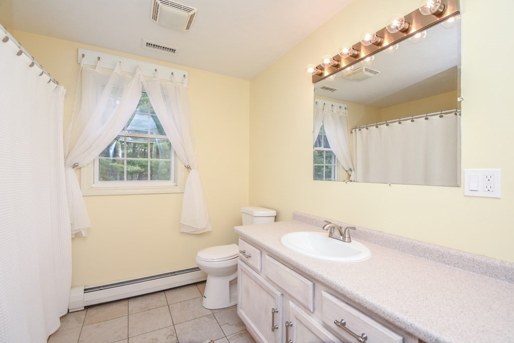 26 Rush Pond Road Lakeville, MA 02347 - Photo 22 of 38 a bathroom with a granite countertop sink mirror vanity and a toilet