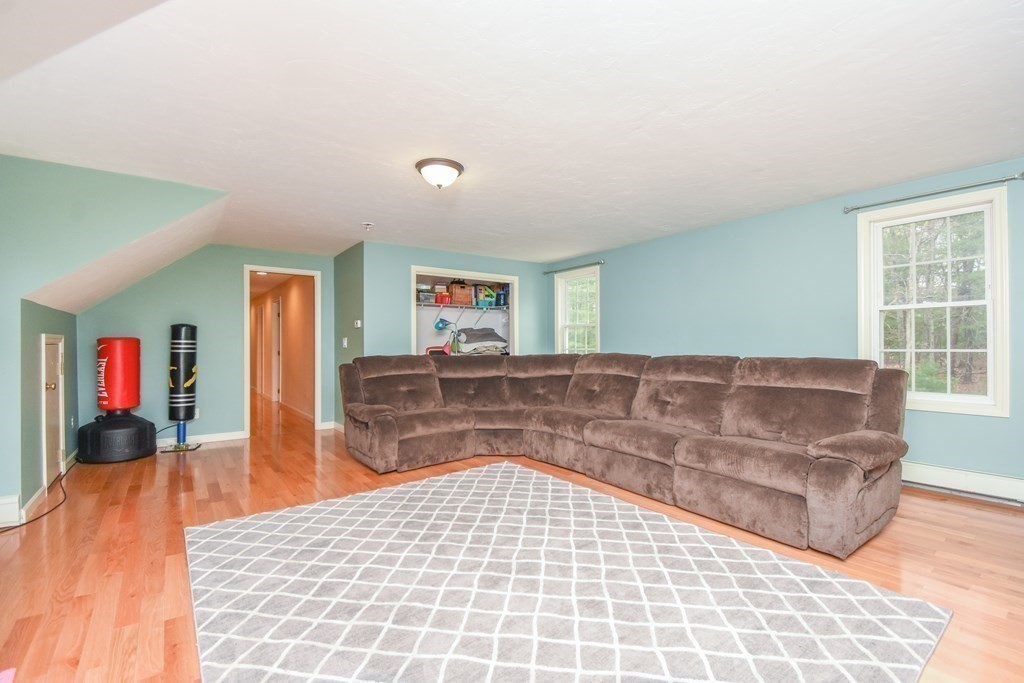 26 Rush Pond Road Lakeville, MA 02347 - Photo 24 of 38 a living room with a couch and a dresser next to a window