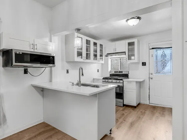 a kitchen with stainless steel appliances granite countertop a sink a stove and cabinets