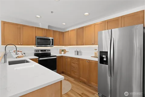 a kitchen with a refrigerator a microwave a sink and cabinets
