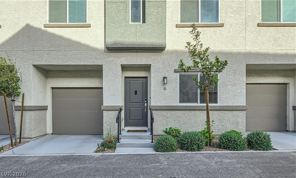12110 Midnight Pine Road, Unit 3 Las Vegas, NV 89183 - Photo 3 of 13 A contemporary townhome facade featuring integrated garages and a welcoming front entrance.