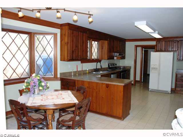7434 Knightly Road Mechanicsville, VA 23116 - Photo 6 of 12 a kitchen with stainless steel appliances kitchen island granite countertop a table chairs and a refrigerator