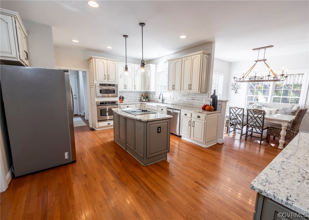 14506 Post Mill Drive Midlothian, VA 23113 - Photo 21 of 48 a kitchen with stainless steel appliances granite countertop a stove a refrigerator a oven a dining table and chairs with wooden floor