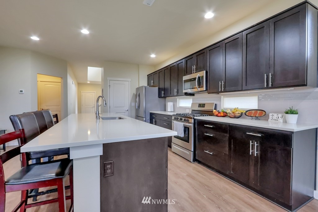 471 Partlon Street Buckley, WA 98321 - Photo 7 of 23 a large kitchen with stainless steel appliances granite countertop a lot of counter space and wooden floor