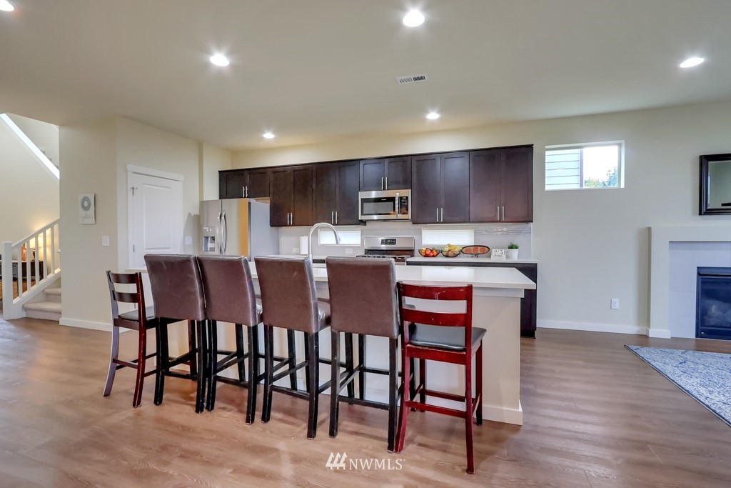 471 Partlon Street Buckley, WA 98321 - Photo 8 of 23 a kitchen with stainless steel appliances granite countertop a table chairs sink refrigerator and cabinets