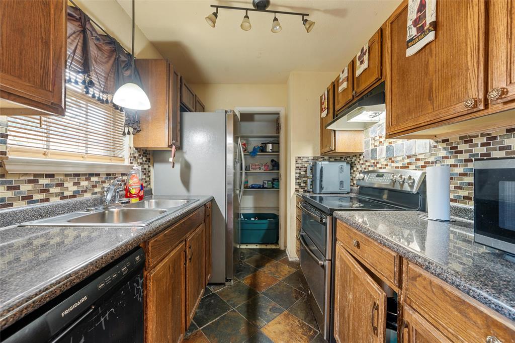 1012 Hatton Street Waco, TX 76704 - Photo 4 of 13 a kitchen with stainless steel appliances granite countertop a sink stove and refrigerator