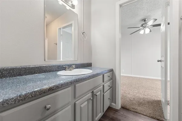 a bathroom with a granite countertop sink and a mirror
