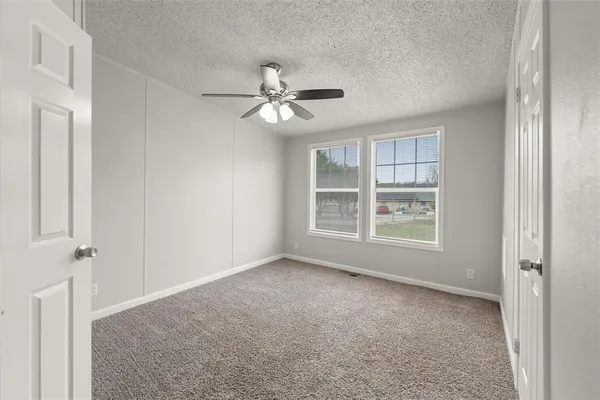 a view of room with a ceiling fan and windows