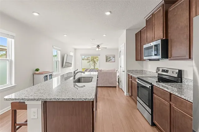 a kitchen with stainless steel appliances granite countertop microwave stove top oven and cabinets