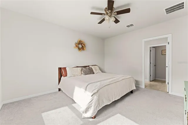 a spacious bedroom with a bed and a ceiling fan