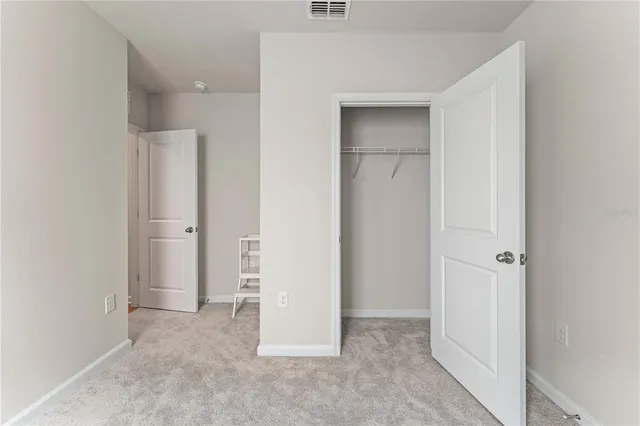 an empty room with closet and a bathroom