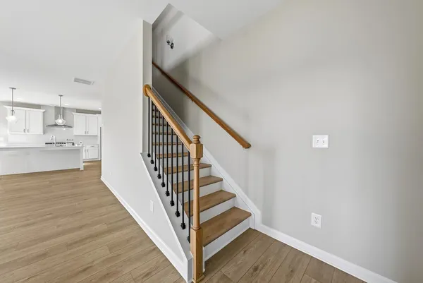 a view of a hallway with wooden floor and staircase