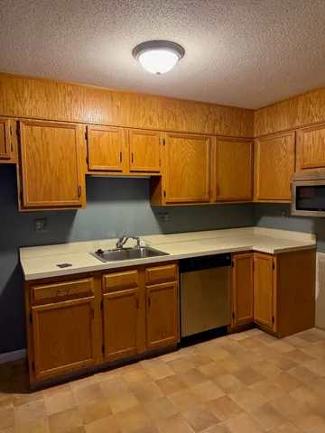 a kitchen with granite countertop a sink and a stove