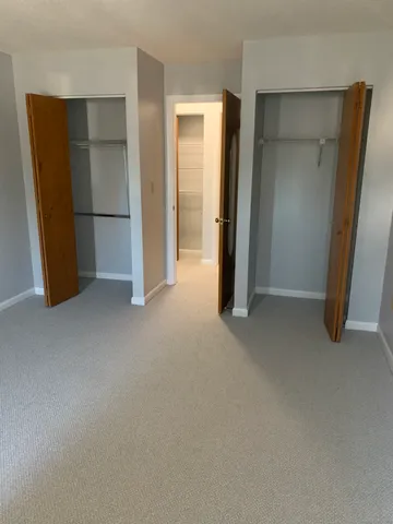 an empty room with closet and mirror